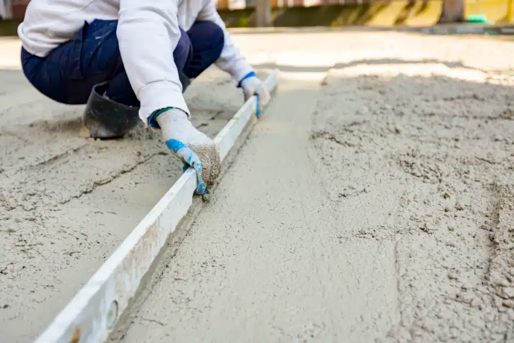 professional worker hand leveling the concrete for private property